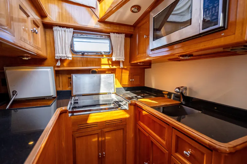 Persistence Yacht Photos Pics Luxurious 2008 Grand Banks 47 Eastbay FB yacht kitchen with wood cabinetry and modern appliances.