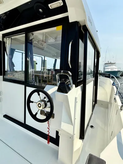  Yacht Photos Pics 2020 Jeanneau NC Sport 895 boat exterior with steering wheel, docked at marina.