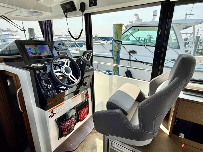  Yacht Photos Pics Interior of 2020 Jeanneau NC Sport 895 boat, featuring helm with steering wheel and navigation equipment.