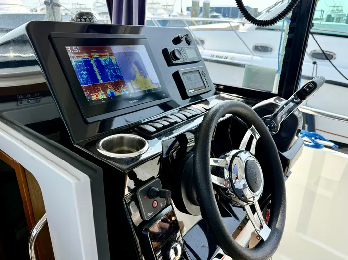  Yacht Photos Pics Helm of 2020 Jeanneau NC Sport 895 with modern navigation equipment and steering wheel.