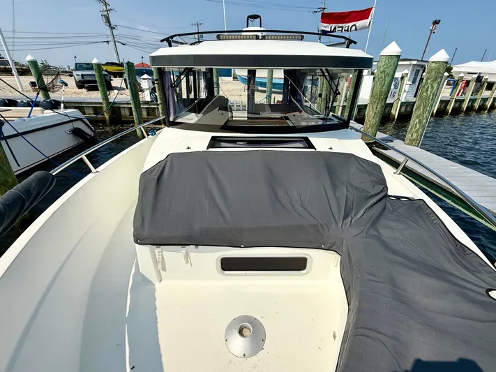 Yacht Photos Pics 2020 Jeanneau NC Sport 895 boat docked, featuring covered seating and sleek design.