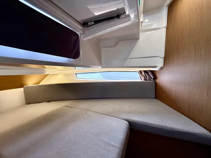  Yacht Photos Pics 2020 Jeanneau NC Sport 895 cabin interior with cushioned seating and wooden accents.