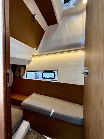  Yacht Photos Pics 2020 Jeanneau NC Sport 895 cabin interior with wooden finish and window.