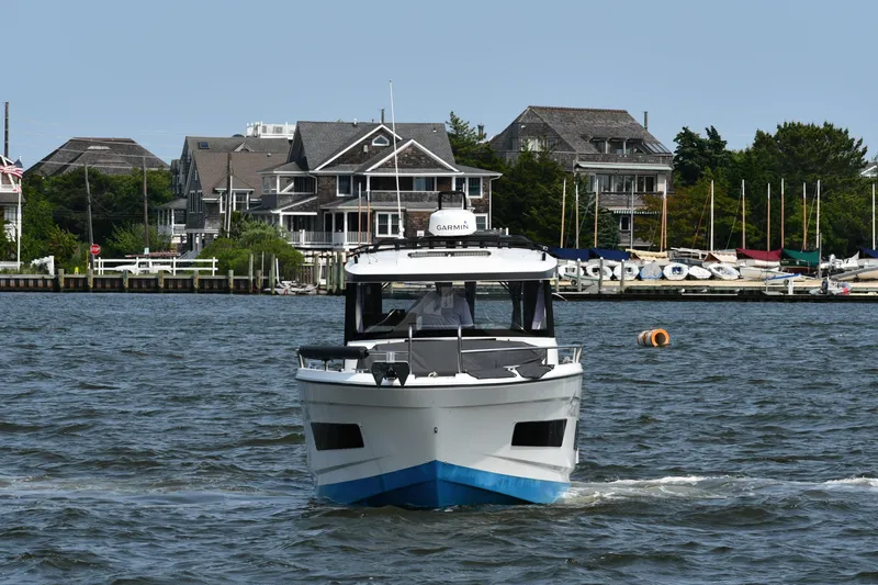  Yacht Photos Pics 2020 Jeanneau NC Sport 895 boat cruising near waterfront homes and docks.