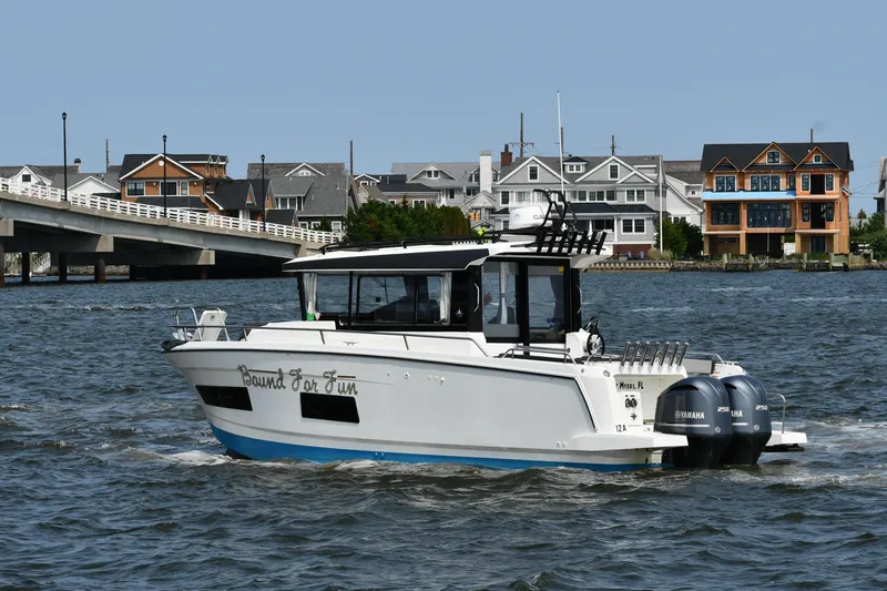  Yacht Photos Pics 2020 Jeanneau NC Sport 895 boat cruising near waterfront homes and bridge.