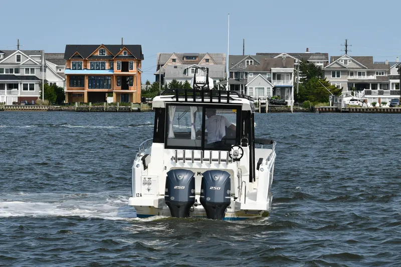  Yacht Photos Pics 2020 Jeanneau NC Sport 895 boat cruising near waterfront homes.