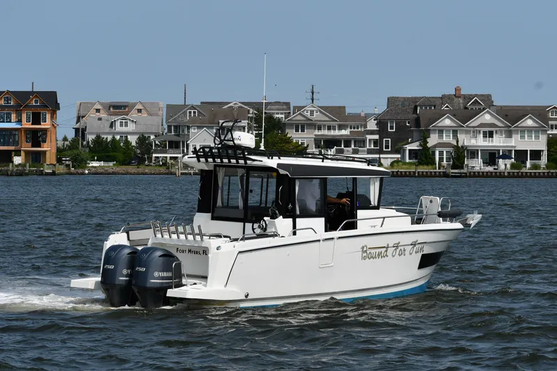  Yacht Photos Pics 2020 Jeanneau NC Sport 895 boat cruising near waterfront homes.