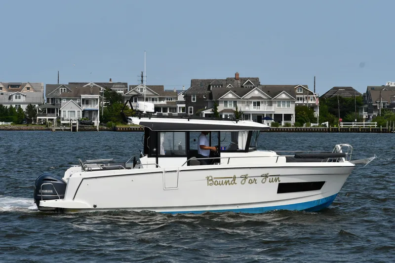  Yacht Photos Pics 2020 Jeanneau NC Sport 895 boat cruising near waterfront homes.