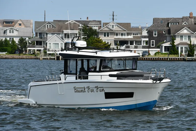  Yacht Photos Pics 2020 Jeanneau NC Sport 895 boat cruising near waterfront homes.