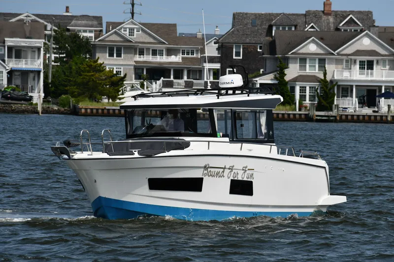  Yacht Photos Pics 2020 Jeanneau NC Sport 895 boat cruising near waterfront homes.