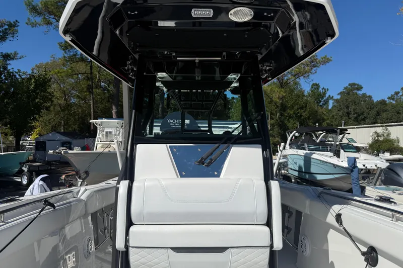  Yacht Photos Pics 2022 Blackfin 272 CC boat interior with seating and console, docked outdoors.