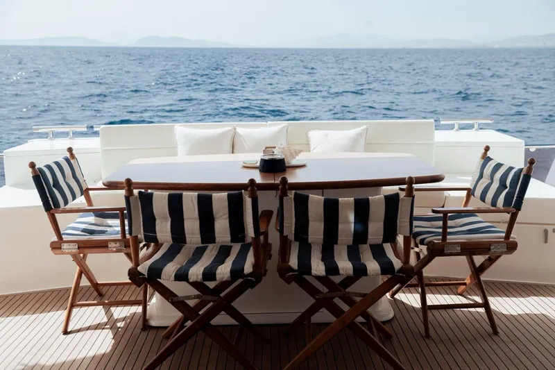 M/y Argo Yacht Photos Pics Outdoor dining area on 2006 Ferretti Yachts 780 with ocean view and striped chairs.