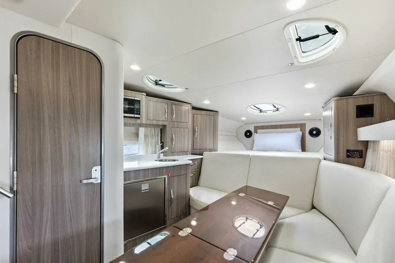 Snuffleupagus Yacht Photos Pics 2020 Regal 33 XO yacht interior with modern kitchen, seating, and sleeping area.
