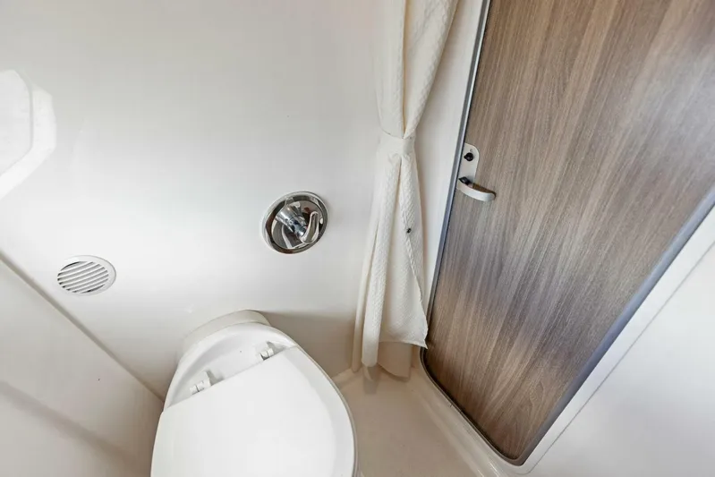 Snuffleupagus Yacht Photos Pics 2020 Regal 33 XO boat bathroom interior with toilet and wooden door.