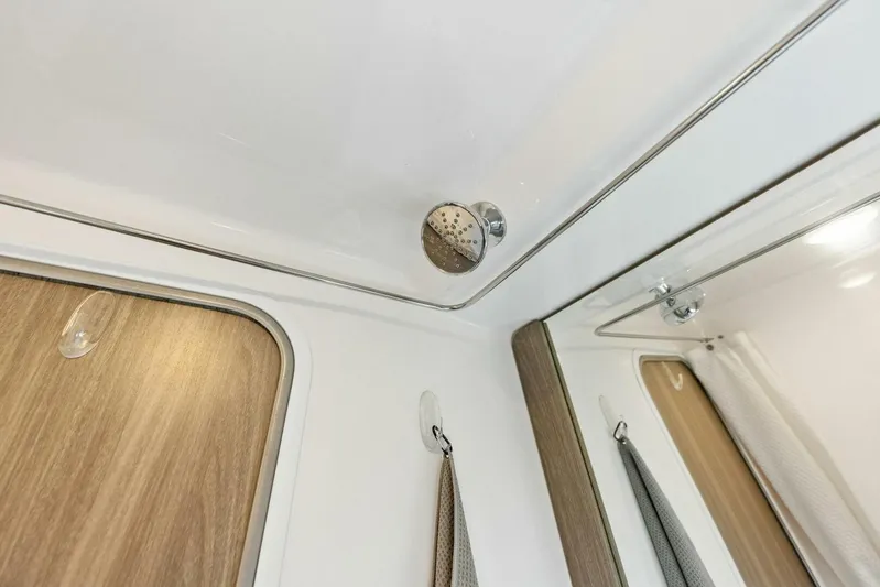 Snuffleupagus Yacht Photos Pics Interior of 2020 Regal 33 XO boat, featuring a modern shower area with wood accents.
