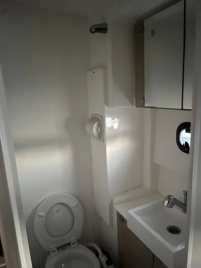  Yacht Photos Pics Compact bathroom in a 2019 Bali 4.3 model, featuring a toilet, sink, and storage cabinet.