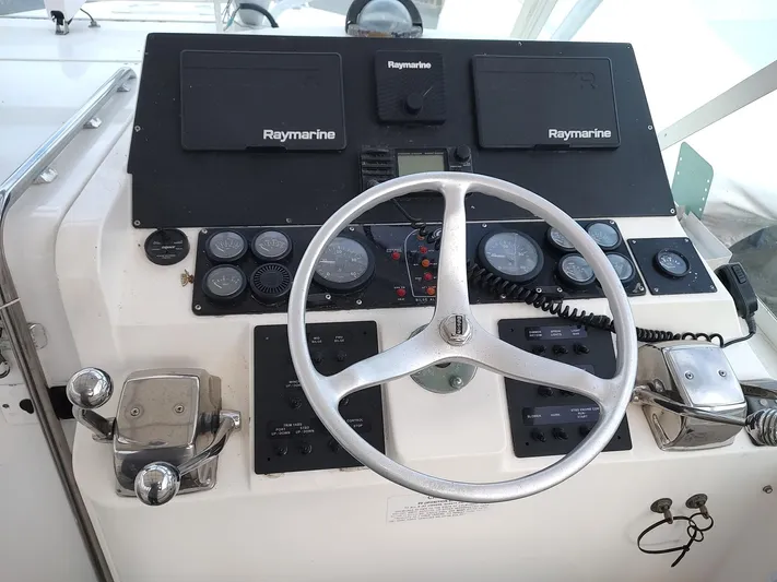  Yacht Photos Pics Helm of 1998 Cabo 31 Express boat with Raymarine navigation equipment and steering wheel.