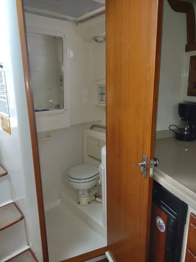  Yacht Photos Pics 1998 Cabo 31 Express boat bathroom with wooden door and compact design.