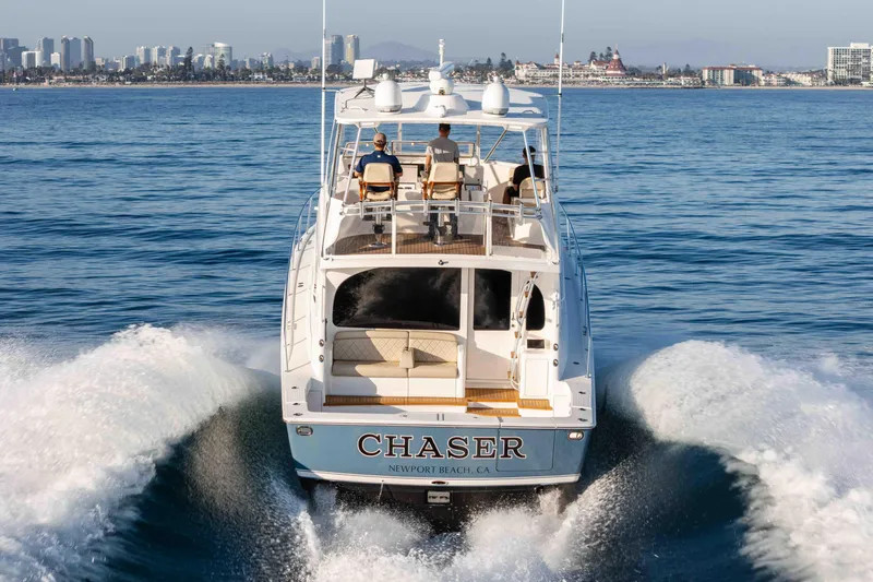 Chaser Yacht Photos Pics 2014 Viking 46 Convertible yacht cruising near city skyline, labeled "Chaser," Newport Beach, CA.