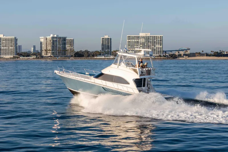 Chaser Yacht Photos Pics 2014 Viking 46 Convertible yacht cruising near coastal city skyline.