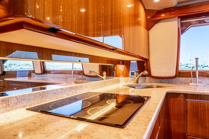 Chaser Yacht Photos Pics Luxurious kitchen interior of 2014 Viking 46 Convertible yacht with modern appliances and wood finish.