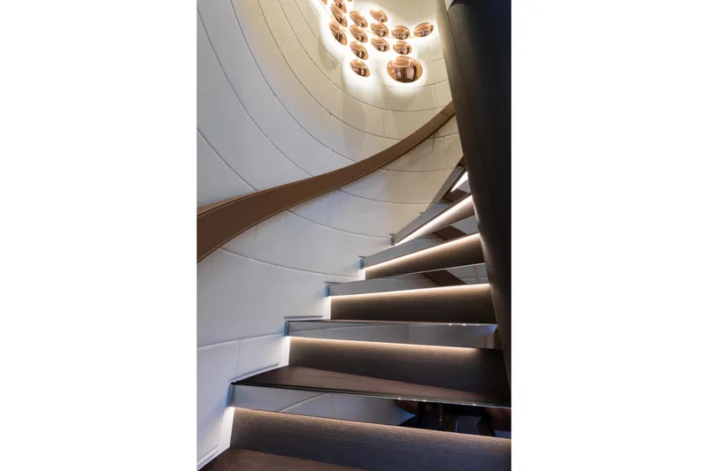 Laurentia Yacht Photos Pics Luxurious spiral staircase in 2017 Heesen Fast Displacement Motor Yacht, featuring modern lighting.