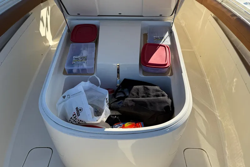 Electric Arc Yacht Photos Pics Storage compartment on a 2018 Scout 350 LXF boat with various items inside.