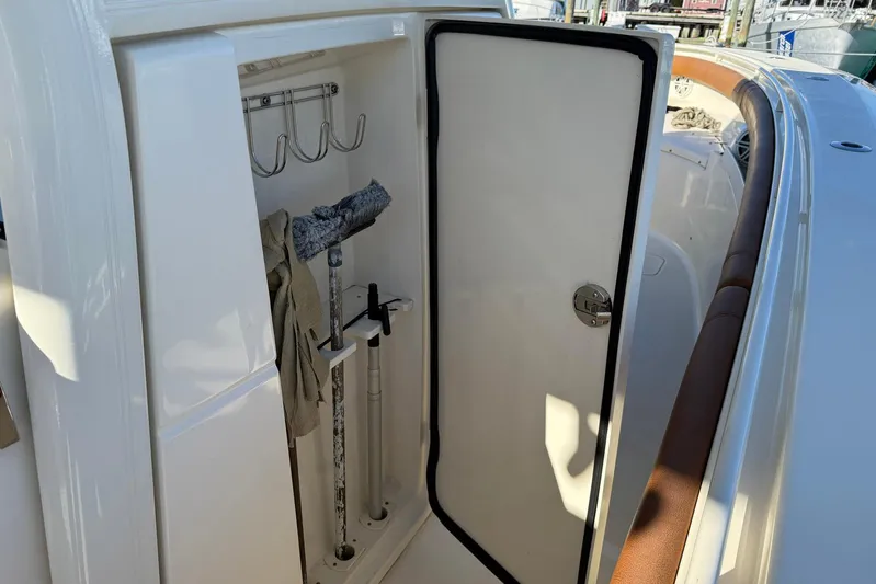 Electric Arc Yacht Photos Pics Storage compartment on a 2018 Scout 350 LXF boat, featuring hooks and cleaning tools.