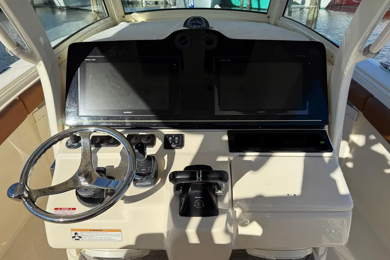 Electric Arc Yacht Photos Pics 2018 Scout 350 LXF boat dashboard with steering wheel and navigation screens.