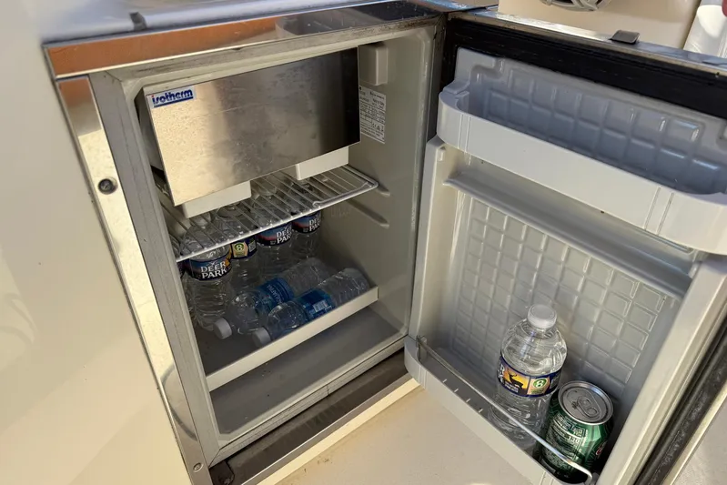Electric Arc Yacht Photos Pics Open mini fridge on 2018 Scout 350 LXF boat, stocked with water bottles and a soda can.