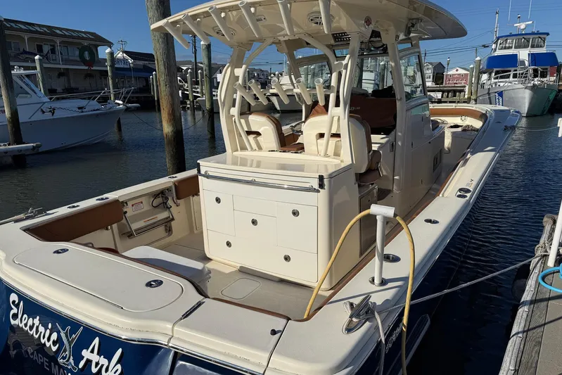 Electric Arc Yacht Photos Pics 2018 Scout 350 LXF boat docked at marina, featuring spacious deck and seating.
