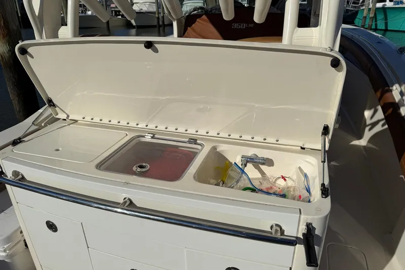 Electric Arc Yacht Photos Pics Open storage compartment on a 2018 Scout 350 LXF boat, showing sink and supplies.