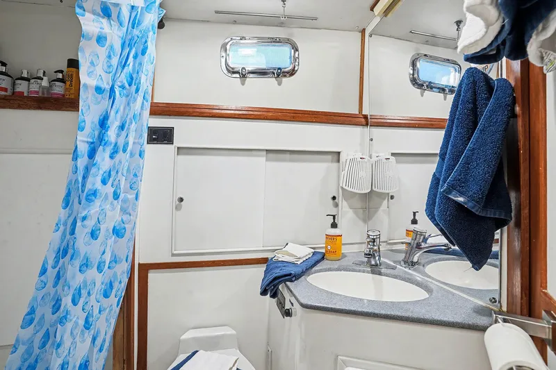 Gypsy Queen Yacht Photos Pics Bathroom on a 1991 Shannon VOYAGER boat with blue towels and shower curtain.