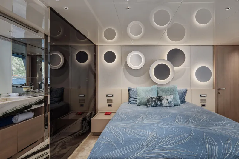 Zafiro III Yacht Photos Pics Luxurious Sanlorenzo SX88 2020 yacht bedroom with modern circular wall design and elegant bedding.