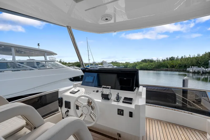 Ascendo Yacht Photos Pics Astondoa 66 yacht helm, 2022 model, with modern controls and scenic marina view.