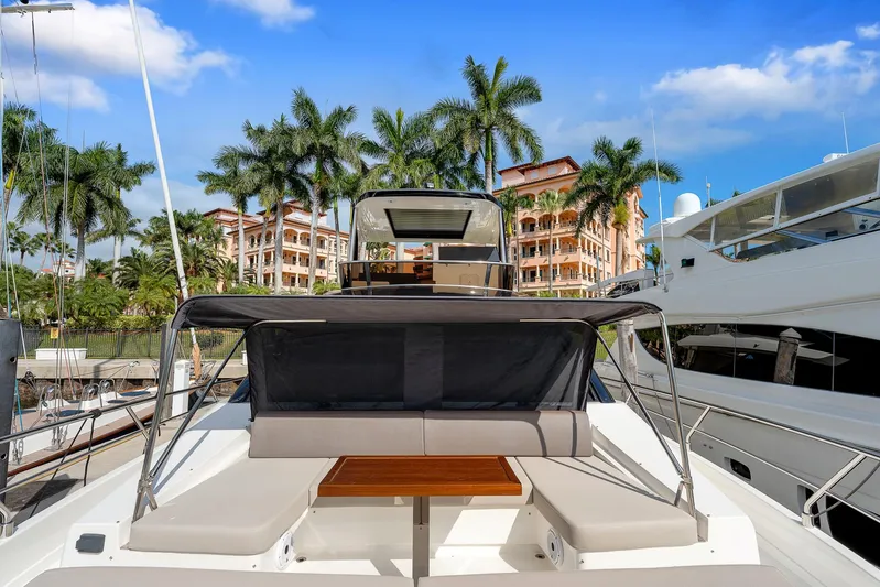 Ascendo Yacht Photos Pics Astondoa 66 yacht, 2022 model, docked with palm trees and buildings in the background.