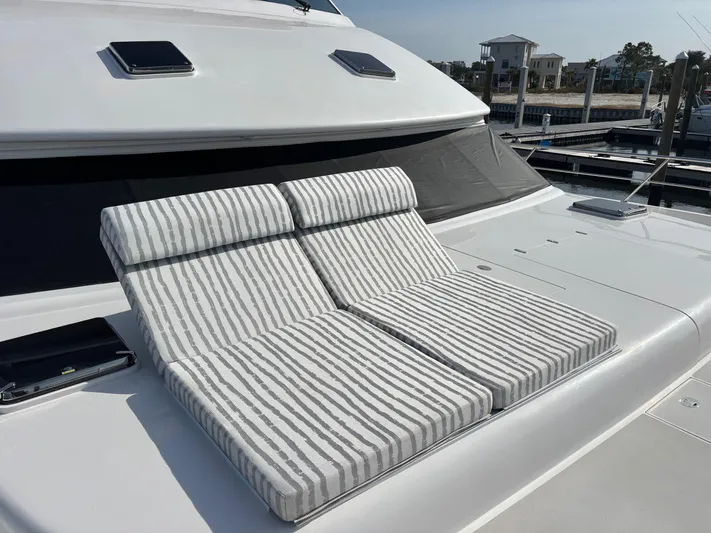 Hideout Yacht Photos Pics Striped lounge chairs on 2022 Horizon PC65 yacht deck, docked at marina.