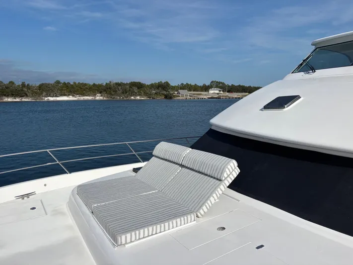 Hideout Yacht Photos Pics Luxury Horizon PC65 yacht deck with striped sun loungers, 2022 model, on serene water.