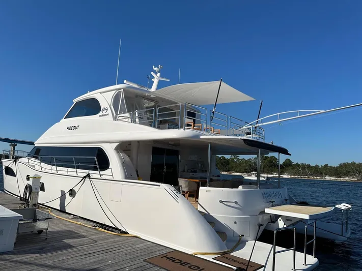 Hideout Yacht Photos Pics Luxury Horizon PC65 yacht docked, 2022 model, with clear blue sky background.