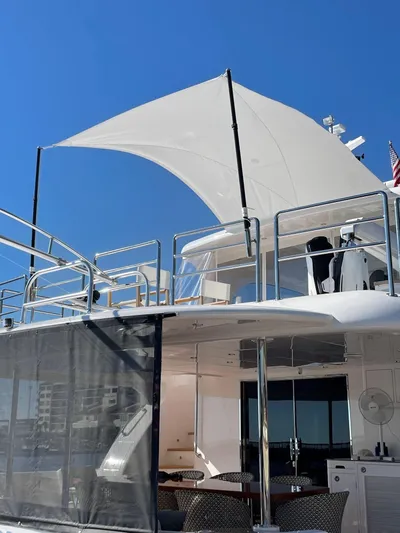 Hideout Yacht Photos Pics Luxury Horizon PC65 yacht with sunshade, 2022 model, under clear blue sky.