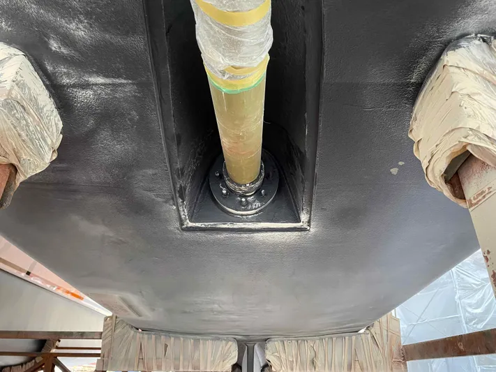 Hideout Yacht Photos Pics Close-up of Horizon PC65 2022 boat hull with propeller shaft installation.