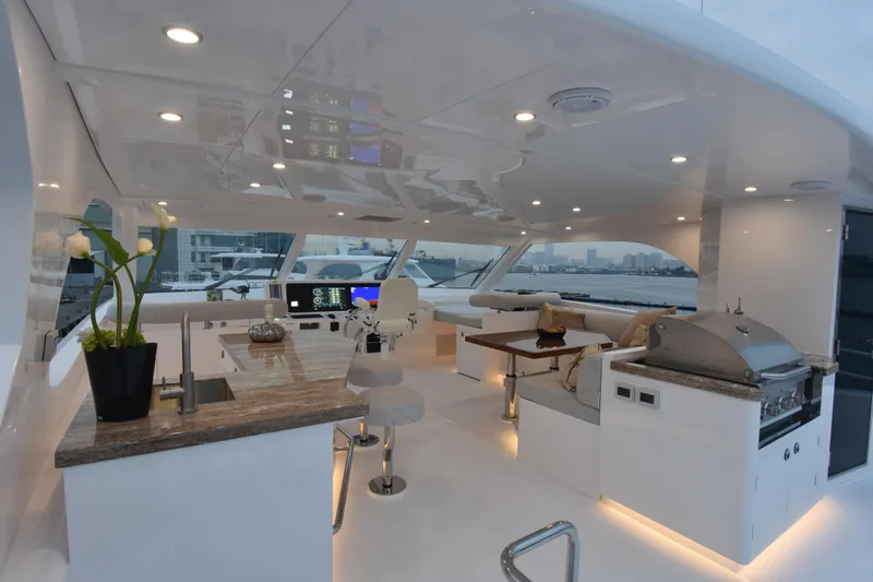 Hideout Yacht Photos Pics Luxurious 2022 Horizon PC65 yacht interior with modern kitchen and seating area.