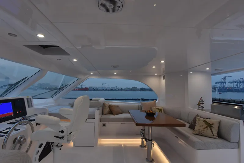 Hideout Yacht Photos Pics Luxurious interior of 2022 Horizon PC65 yacht with modern seating and navigation area.