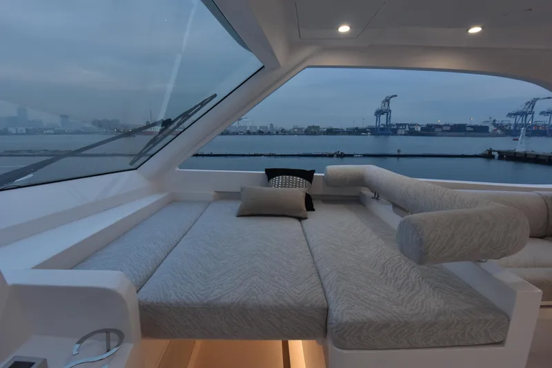 Hideout Yacht Photos Pics Luxurious interior of 2022 Horizon PC65 yacht with waterfront view at dusk.