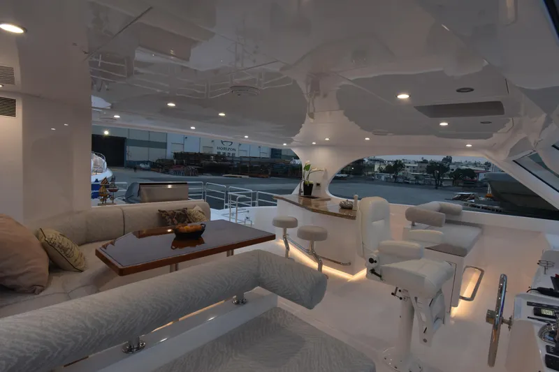 Hideout Yacht Photos Pics Luxurious 2022 Horizon PC65 yacht interior with elegant seating and modern lighting.