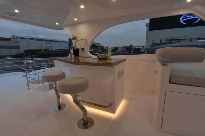 Hideout Yacht Photos Pics Luxurious 2022 Horizon PC65 yacht interior with elegant bar and seating area.