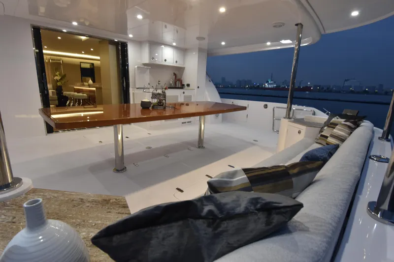 Hideout Yacht Photos Pics Luxurious Horizon PC65 yacht interior, 2022 model, featuring elegant seating and dining area at dusk.