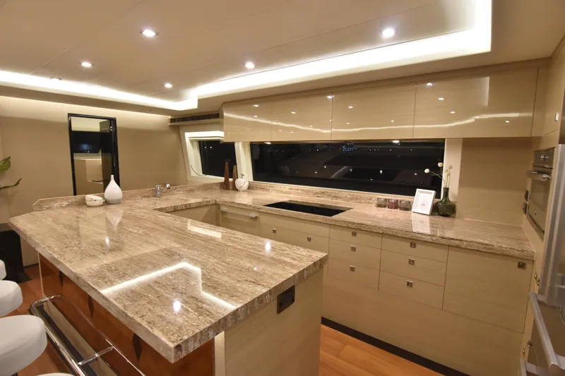 Hideout Yacht Photos Pics Luxurious yacht kitchen with marble countertops, modern lighting, and sleek cabinetry. Horizon PC65, 2022 model.