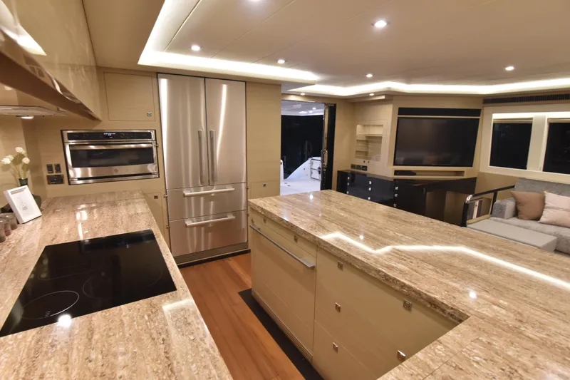 Hideout Yacht Photos Pics Luxurious kitchen interior of 2022 Horizon PC65 yacht with modern appliances and elegant design.
