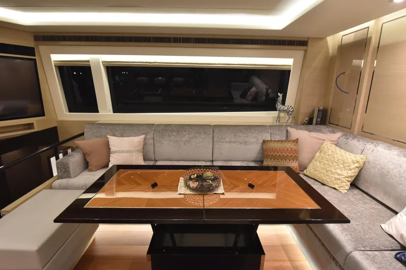 Hideout Yacht Photos Pics Luxurious interior of 2022 Horizon PC65 yacht with elegant seating and decorative pillows.